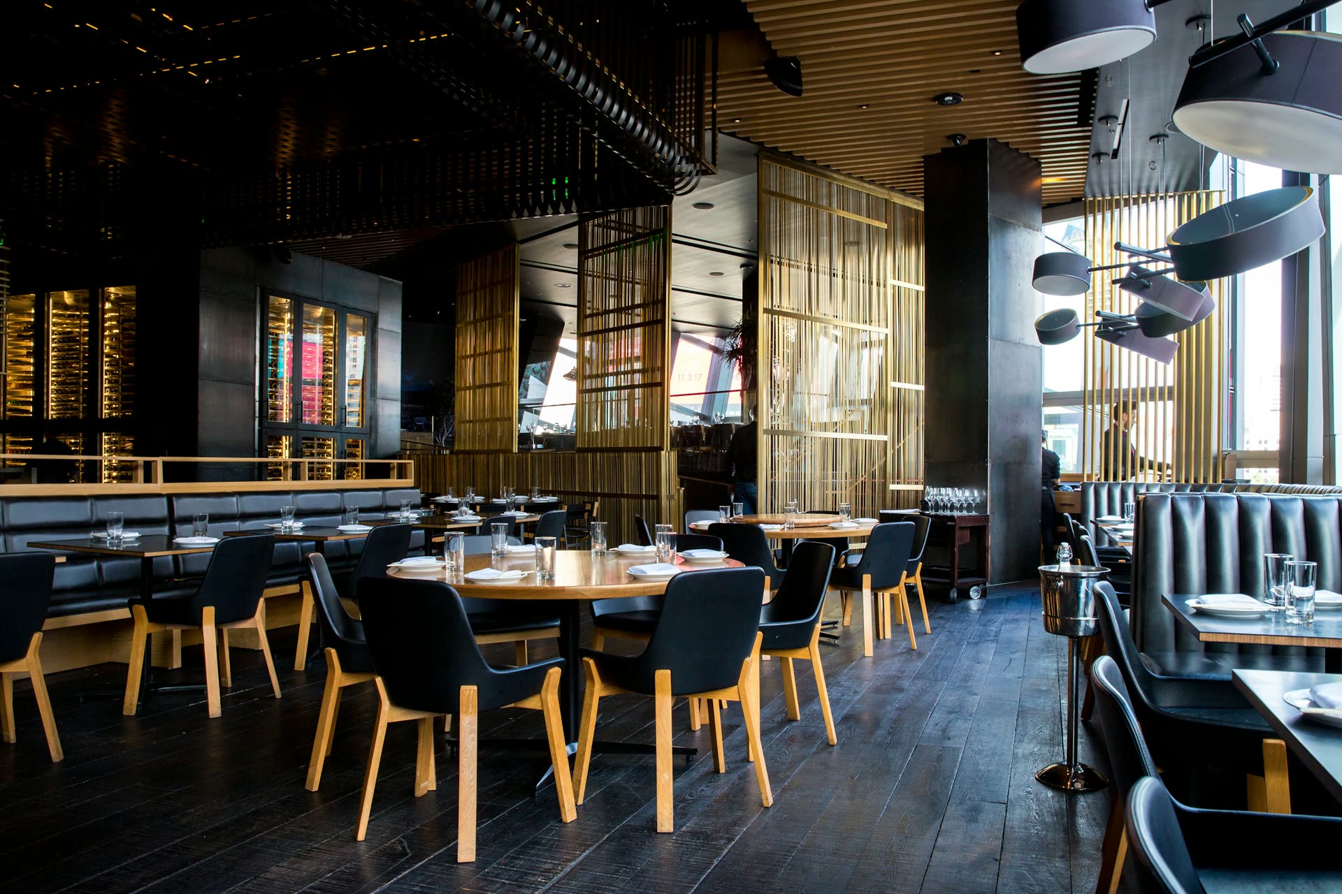 Warm restaurant dining room with pendant lights and set tables